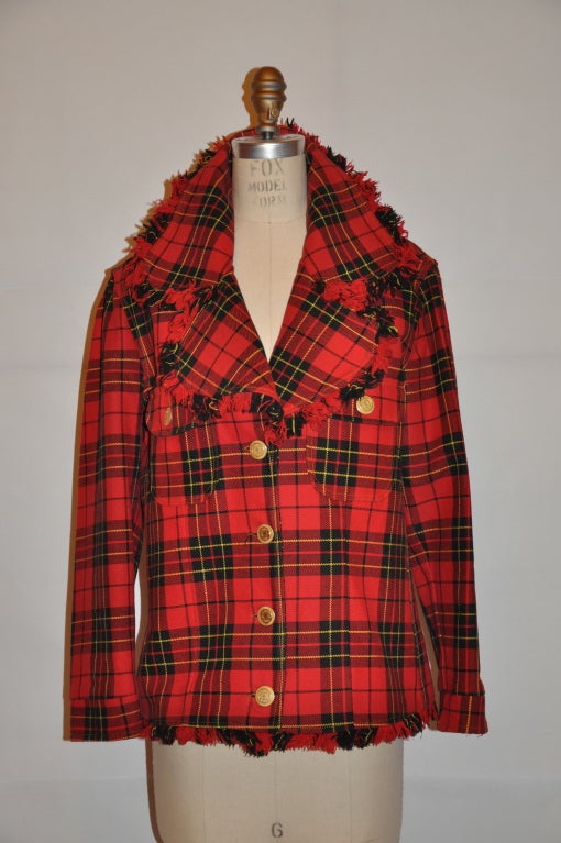 Moschino red, black and yellow plaid jacket has fringed detailing along the lapels and also on the jacket's hemline. There are two patch pockets in front with detail metal hardware buttons. The lining is in black. The front measures 15