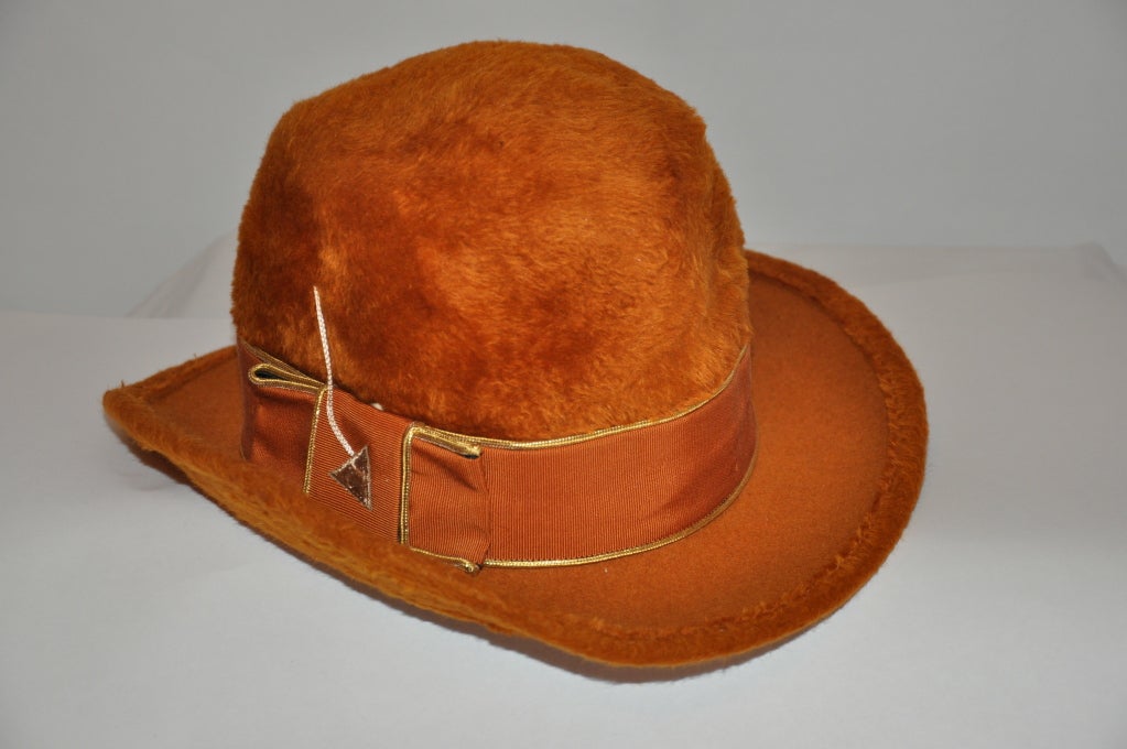 Mr. John felted hat is in a warm-golden brown hue. The body is crafted in Italy. There's a ribbon and embroidered 