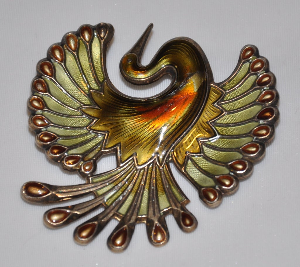 David Andersen large bird brooch in hues of greens, with accents of red. Measures 2 inches x 2 inches. Brooch is signed and marked in back. Based is Sterling, followed by enamel finish.