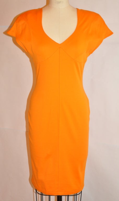        Thierry Mugler iconic signature Neon-tangerine cotton form-fitting asymmetrical-cut dress has padded shoulders. The center back invisible zipper measures 19