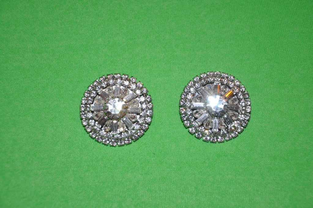 These '60s rhinestones clips on earrings are simple, yet elegant. Center stone is round with marquis and retangle shape surrounding and the outer edge are small round stones. Simply elegant! the stones are set in silver-toned metal. Just in case you