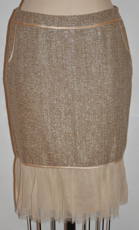 Burberrys fully-lined skirt is a weave blend of metallic, taupe, and beige threads. Soft to the touch and weight-less. The hemline is detailed with seven inches of sheer beige chiffon trim. There are two side lined pockets.<br />
  Waist measures