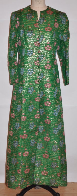 This wonderful fully-lined Bergdorf Goodman evening coat has gold metallic threads running through like clouds in the sky surrounded by hand-done embroidered hues of blues and pinks in a floral pattern. The front has ten (10) same fabric-covered