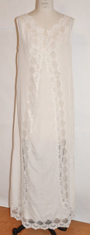 Christian Dior white negligee has panels of imported lace along the front , and also along the hemline. There's a hidden single button on front at the top of the center lec.
   The front measures 45