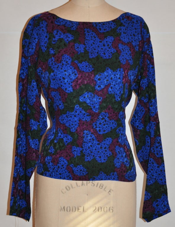 Yves Saint Laurent multi-colored floral print of violets, greens, plums, and black is made of silk crepe de chine. The neck neck has a single button clousure.
   The front measures 19