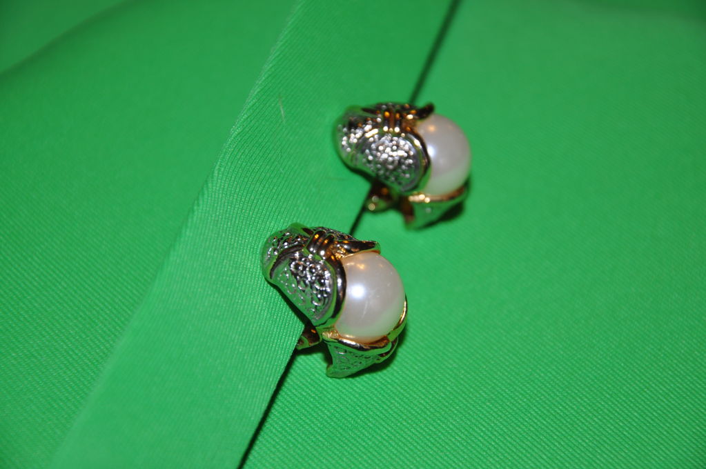 Ces boucles d'oreilles à clip en métal doré ont une perle de 3 cm sertie au centre. Tout simplement élégant ! La longueur est de 1 1/4