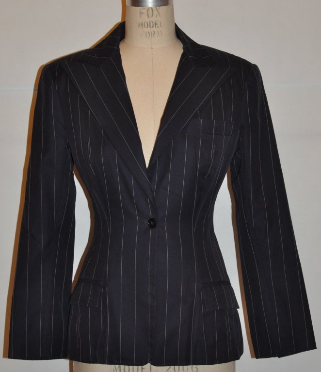 Norma Kamali spring navy wool pinstripe jacket has two set-in pockets along with a breast pocket. The hemline is slightly flared.
   The back measures 25
