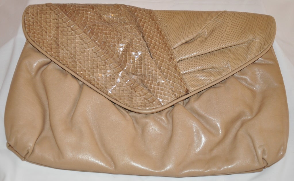This Morris Moskowitz beige clutch has a detachable leather shoulder strap for your choice of wearing the bag during the daytime and into the evening as a clutch. The soft leather clutch is fully lined with a zipper compartment. The flap has a