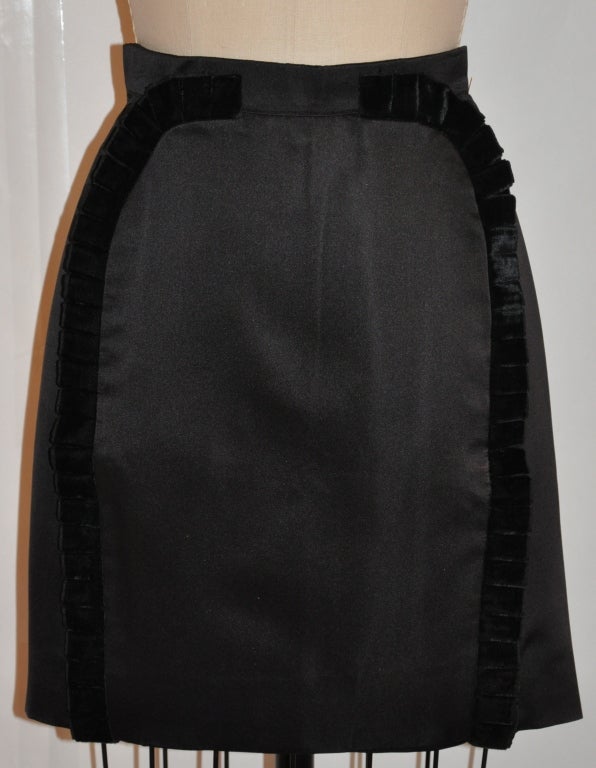 Valentino black silk satin skirt has black pleated ribbon accents on the front. The skirt is fully lined with a waistband which measures 1 3/8