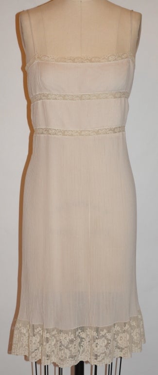 Alberta Ferretti cream dress has micro flat-pleating accented with imported hand-made Swiss lace along the hem. The height of the border lace measures 4 inches. The back has a center back zipper which measures 7 inches below the three silk ties. The