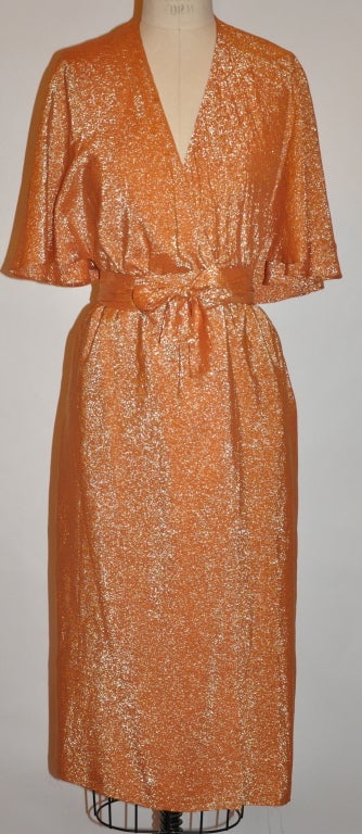Halston signature iconic tangerine metallic-silk lame orange wrap-around dress is backless. There's a cape-like extended collar that draps over the backless creating a flowing shawl-like effect. Original tags still attached.
   The length of the