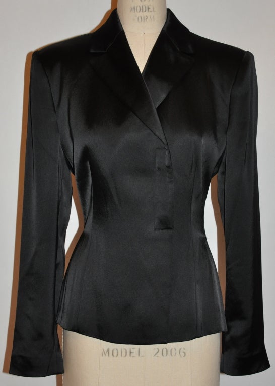 Giorgio Armani black evening jacket is fully lined with padded shoulders. The front has two hidden buttons which are covered with the same silk material as the jacket itself.
   The sides have 'V' cut open slits which measures 7 1/4