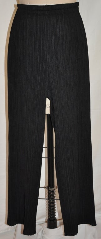 Issey Miyake black pant has the signature pleated material. The elastic waistband measures 24