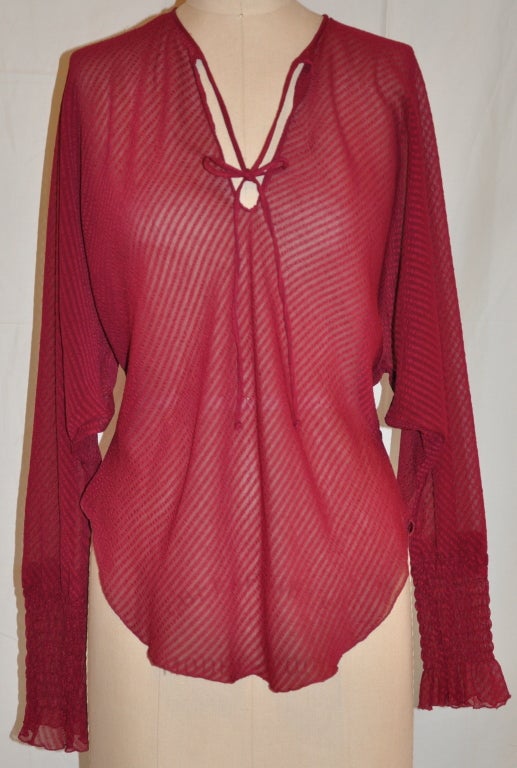 Sheer stripe-on-stripe burgundy blouse is cut on the bias calling for a body-hugging fit. The sleeves have detailing along the cuffs ceating a soft appearance with domain sleeves.
   The front length measures 16 1/2