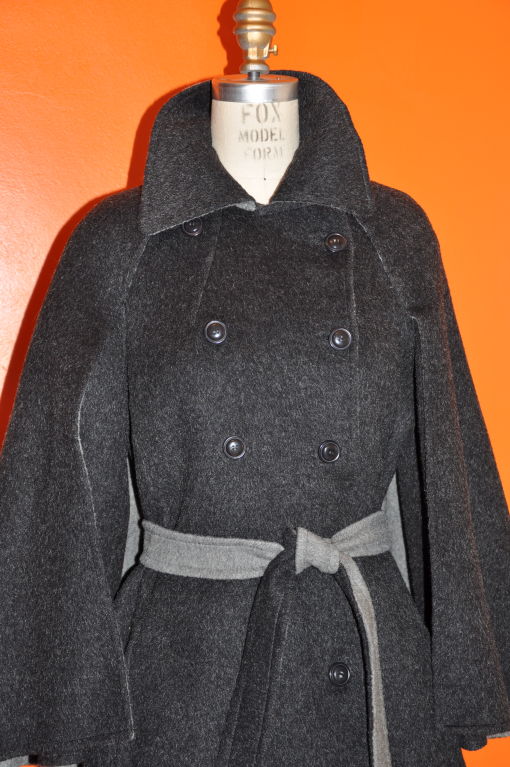 This Tilli Brungnoli, Roma for Saks Fifth Avenue wool and mohair blended double-faced trench style coat with caplets is the perfect coat for the cold months ahead. The coat is charcoal faced and the underneath side is gray in color. There's also a