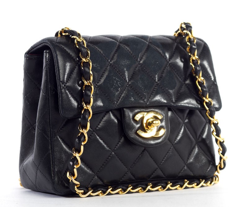 This is an authentic CHANEL Black Lambskin Mini Flap Bag. Done in classic Chanel Diamond quilting, this bag is a classic.  It has signature burgundy rouge toned leather interior with golden hardware on the double CC turnlock closure and chain