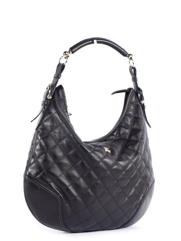 This is an authentic BURBERRY Prorsum Black Leather Quilted Large Hobo Bag. It is done in elegant quilted black leather with smooth leather trim and pale golden hardware. This bag features a single rounded hobo handle and a zippered top closure. The