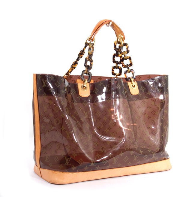This is an authentic LOUIS VUITTON Sac Cabas Ambre GM Tote Large Bag. It is done in monogram vinyl and natural cowhide leather. This bag features dual shoulder straps done in natural cowhide leather and tiger's eye chain links. The bag features a