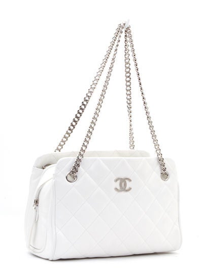 This is an authentic CHANEL White Lambskin Quilted Timeless Tote Bag Bijoux Chain. It is done in white lambskin with shiny silver hardware. This bag features a classic Chanel diamond quilted exterior and a spacious interior, with two exterior