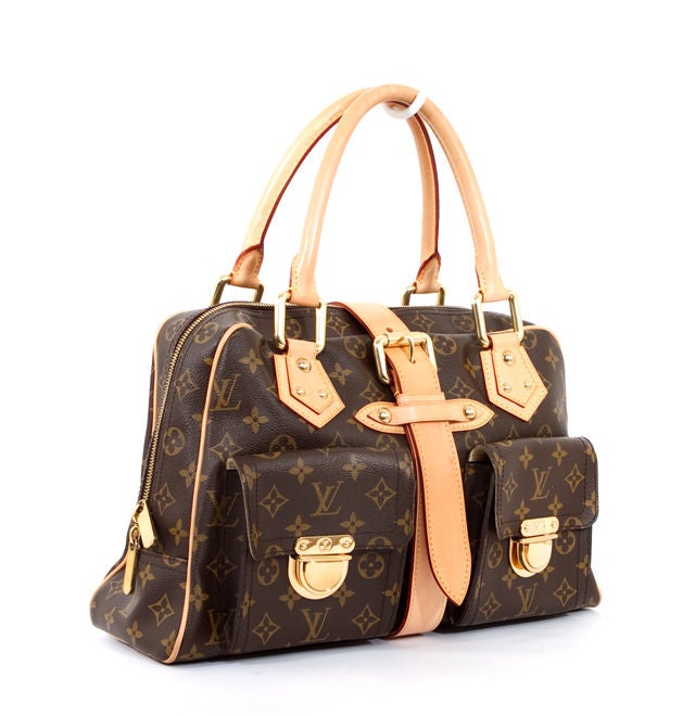 This is an authentic and simply lovely Louis Vuitton Manhattan GM bag purse. This much sought after bag from Louis Vuitton is done in signature LV monogram canvas with dual rolled handles in vachetta leather trim. The bag has an oversize front front