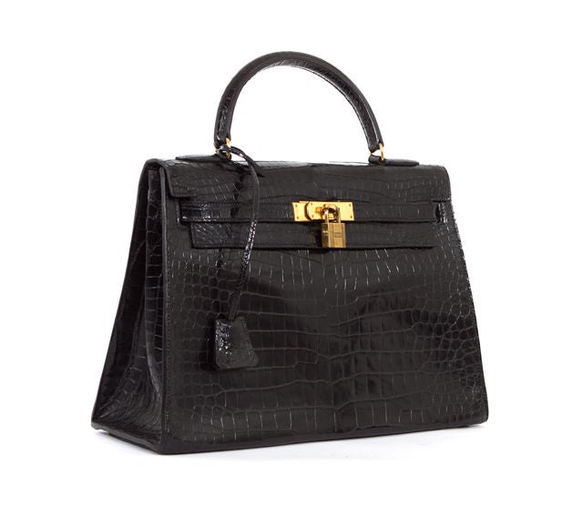 This is an authentic HERMES Rare Black Crocodile GHW 32 cm Kelly Bag Authentic. It is done in gorgeous Crocodile material with gold hardware. It features a single leather handle and the signature Hermes flap top closure with leather strap over round