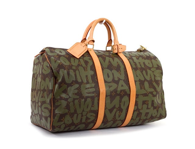 This is an authentic Louis Vuitton Silver Stephen Sprouse Graffiti Keepall 50 Bag. Done in durable LV canvas, this keepall features the signature LV pattern with an overlay of khaki print graffiti. The spacious bag has a top zip closure with golden