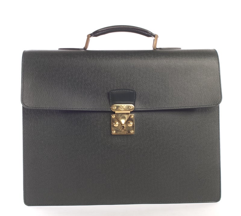 This is a classic and authentic Louis Vuitton Robusto Briefcase done in green taiga leather with elegant gold tone hardware. It is a double compartment briefcase with plenty of room for important papers and even your laptop. It features a single top