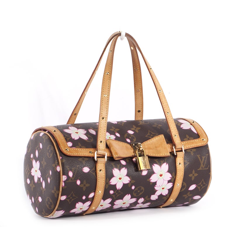This is an authentic LOUIS VUITTON Monogram Cherry Blossom Papillon Bag Purse. It is done in traditional monogram coated canvas with a fun cherry blossom pattern overlay, vachetta leather trim and gold tone hardware. The bag features a rounded