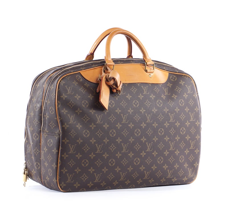 This is an authentic Louis Vuitton Monogram Alize 24 Heures Soft Travel Bag. This is the perfect accessory to take with you on your next weekend getaway! It is done in signature Louis Vuitton monogram canvas with vachetta leather trim and gold tone