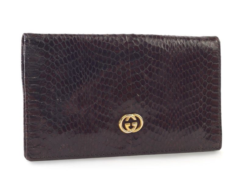This is an absolutely stunning and authentic GUCCI Vintage Python Checkbook Holder Wallet. It is done in luxurious chocolate colored python snakeskin leather with golden hardware. The interior features plenty of room for all of your cards, bills,