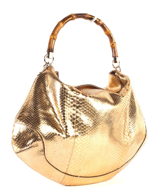This is a preowned authentic GUCCI Copper Python Bamboo Handle Peggy bag.  Done in luxurious copper python leather with matching trim and pale gold hardware, this exotic hobo style is sure to glam up any outfit. It features a signature GUCCI bamboo