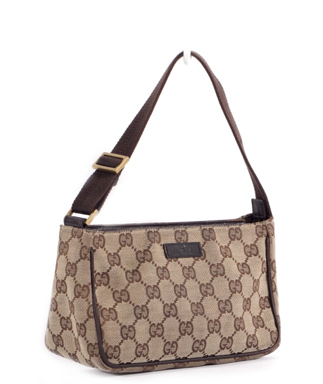 This is an authentic Gucci Beige Ebony GG Monogram Small Pochette Bag. It is done in signature Gucci monogram canvas with chocolate leather trim and gold tone hardware. The bag features a single flat canvas handle and a zipper top closure. The