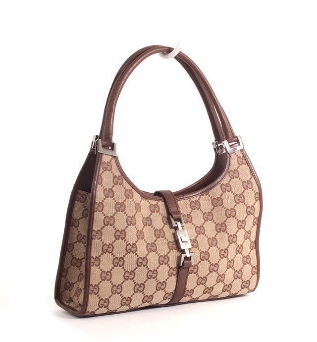 This is an authentic Gucci Monogram Bardot Bag. Done in traditional Gucci monogram canvas, with smooth chocolate leather trim and silver-toned hardware, this gorgeous bag is sure to compliment any outfit. The exterior features two comfortable rolled
