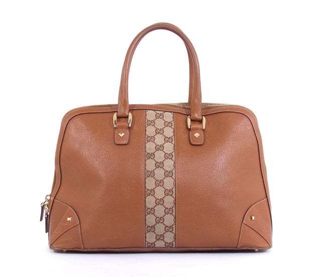 This is an authentic GUCCI Saddle Brown Monogram GG Large Tote Shopper Bag. Done in stunning camel colored leather, this bag features leather trim, a monogram canvas strip down its center, gold toned hardware, studded hardware accents, two rolled