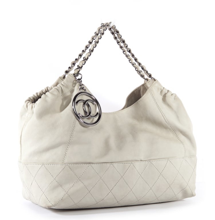 This is an authentic Chanel Ivory Classic Coco Cabas Tote bag. It is done in luxurious soft lamb leather with matching silver colored hardware, and signature Chanel quilted details. It features lovely chain and leather entwined straps and a Chanel
