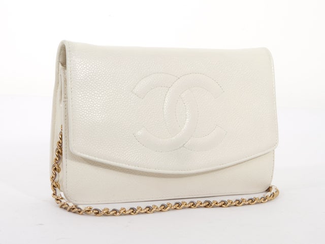 This is an authentic Chanel White WOC Wallet on a Chain bag. Done in lovely white Caviar Leather, this bag features a lovely stitched signature Chanel logo on the front flap and a snap closure, as well as a long leather and chain strap with gold