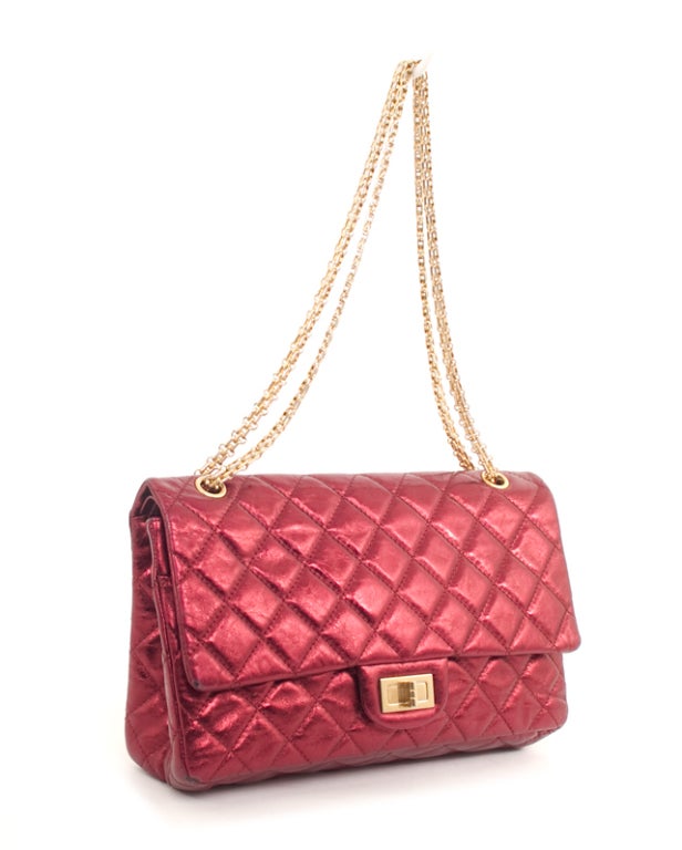 This is an authentic CHANEL 2.55 227 Reissue Dark Red Fuschia Metallic Flap Bag. It is done in a metallic fushia quilted leather with gold hardware. The exterior features one flat pocket, gold chain double strap, and a re-issue turn-lock closure.