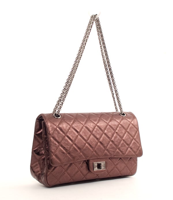 This is an authentic CHANEL 2.55 227 Reissue Bronze Metallic Flap Bag New. It is done in a metallic bronze quilted leather with silver hardware. The exterior features one flat pocket, silver chain double strap, and a re-issue turn-lock closure. The