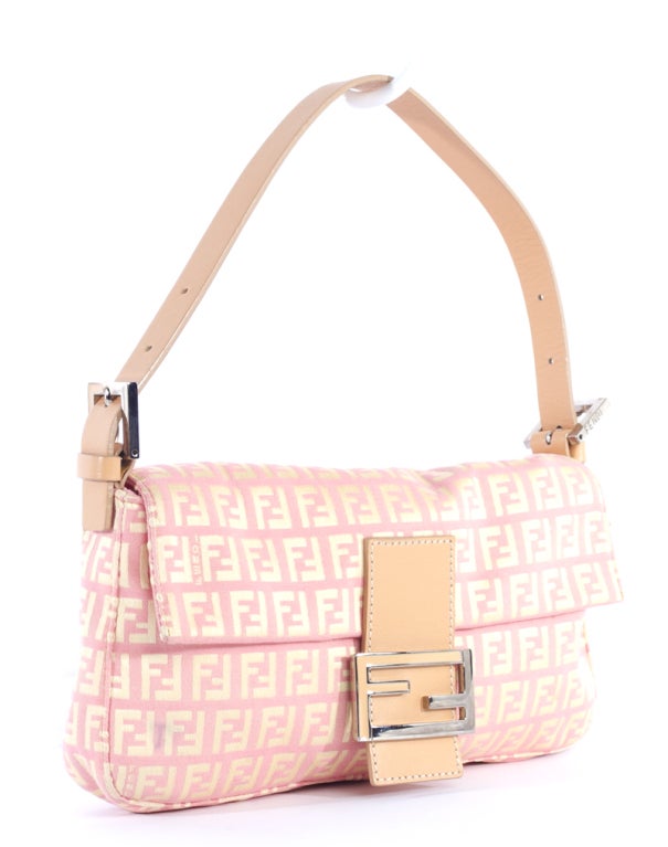 This is an authentic FENDI Light Pink Monogram Pochette Zucchino Baguette New. It is done in light pink signature FENDI monogram canvas on the front and back panels with beige leather trim and silver hardware. The bag features an eye catching flap