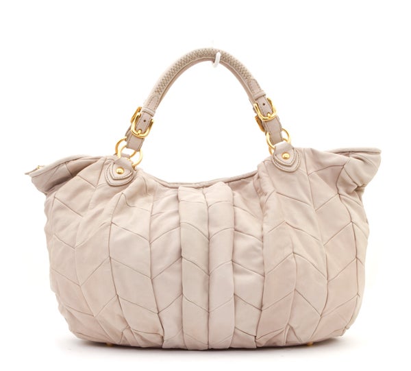 This is an authentic MIU MIU Napa Beige Leather Large Patchwork Tote Bag. This bag is done in lovely beige patchwork leather with gold hardware.  This bag features double rolled leather handles, a single zipper closure, four feet on the base of the