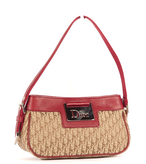 This is an authentic Christian Dior Red Monogram Pochette. It is done in beige signature Dior monogram canvas with red leather trim and silver toned hardware. The bag features a single adjustable red canvas and leather shoulder strap, a zipper top