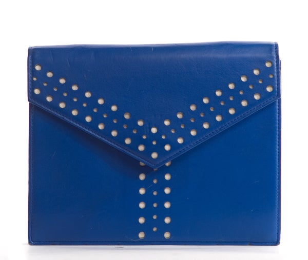 This is an authentic Yves Saint Laurent Azur vintage Y Clutch. This bag can be worn as a crossbody or over the shoulder. It features an adjustable strap, envelope style kisslock closure, and unique perforated front Y detailing. The color is vibrant