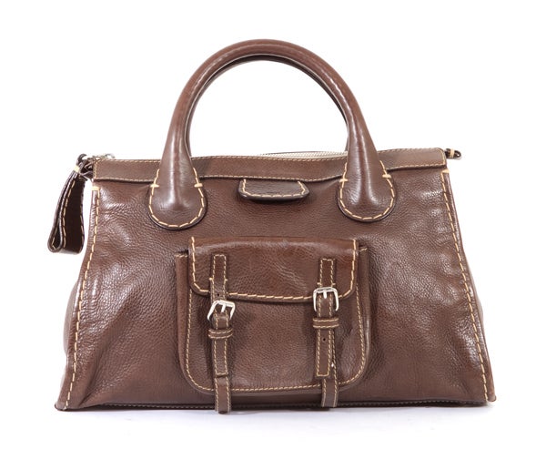 This is an authentic CHLOE Brown Whiskey Large Edith Tote Bag. It is done in soft supple dark brown leather. This bag features dual rolled leather handles, a front patch pocket, a single zip closure, an oversized zipper pull, five protective feet on