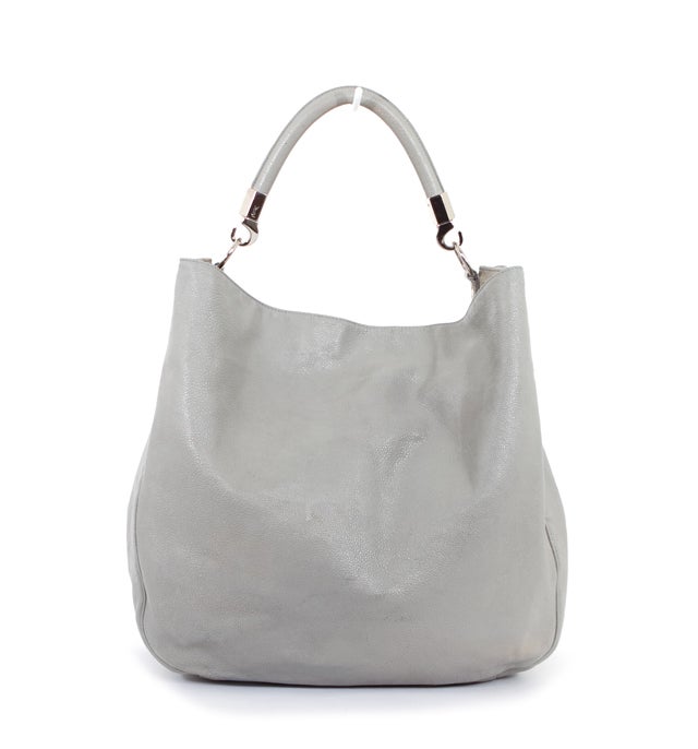 This is an authentic YSL Yves Saint Laurent Grey Stingray Large Roady Bag. Done in grey polished leather, this simple hobo tote is great for all your essentials. The hardware is a lovely silver tone. The interior is done in a soft black textile.