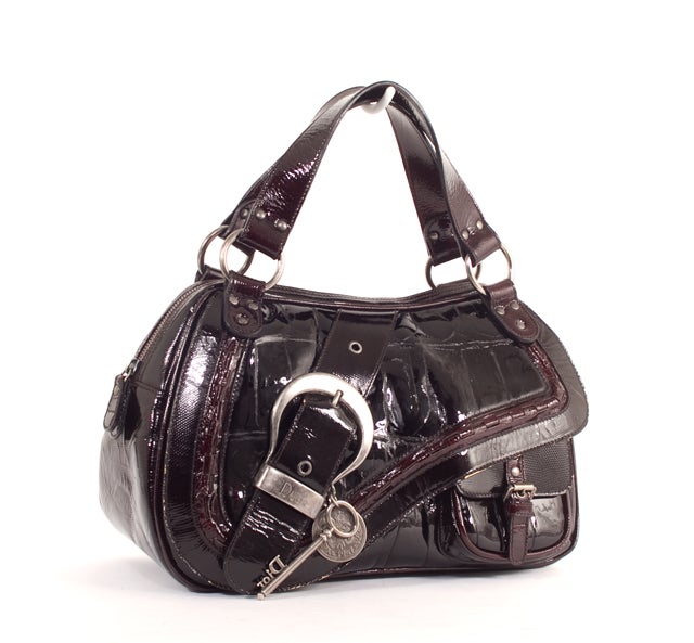 This is an authentic CHRISTIAN DIOR Croc-Stamped Patent Leather Gaucho Bag. Done in a plum colored crocodile embossed patent leather with antique silver hardware, this bag is highly sought after by Dior lovers everywhere.  A limited edition model of