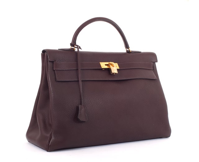 This is an authentic HERMES Clemence Brown Kelly 40 cm Handbag Gold Hardware. It is done in gorgeous chocolate brown leather with gold hardware. It features a single rolled leather handle and the signature Hermes flap top closure with leather strap