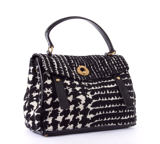 This is an authentic YSL Yves Saint Laurent Muse Two Tweed Black White Bag Purse Rare. It is done in a lovely black and white tweed with black patent leather trim. This bag features a single flat leather handle, a flap over closure, dual front