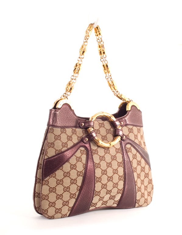 This is an authentic GUCCI Bamboo Ring Limited Edition RUNWAY Dragon Bag. This bag is done in stunning GG monogram canvas and plum leather trim with gold hardware. It features a front gold enamel bamboo ring, leather trim, and dual gold link and