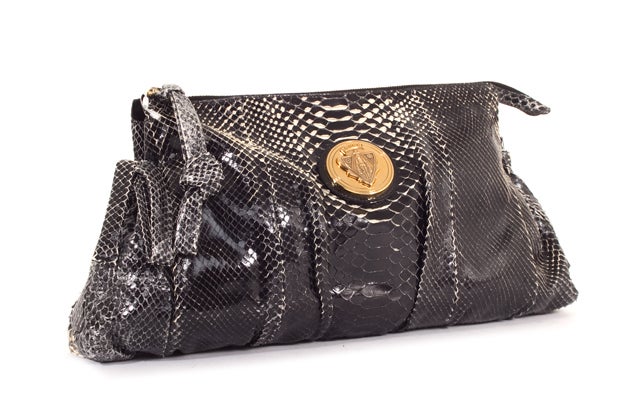 This is an authentic GUCCI Black Python Large Hysteria Clutch Bag. Done in stunning black python, this beauty features gold hardware, side bows, and a simple zip closure. The interior is done in coordinating black textile with the Gucci logo