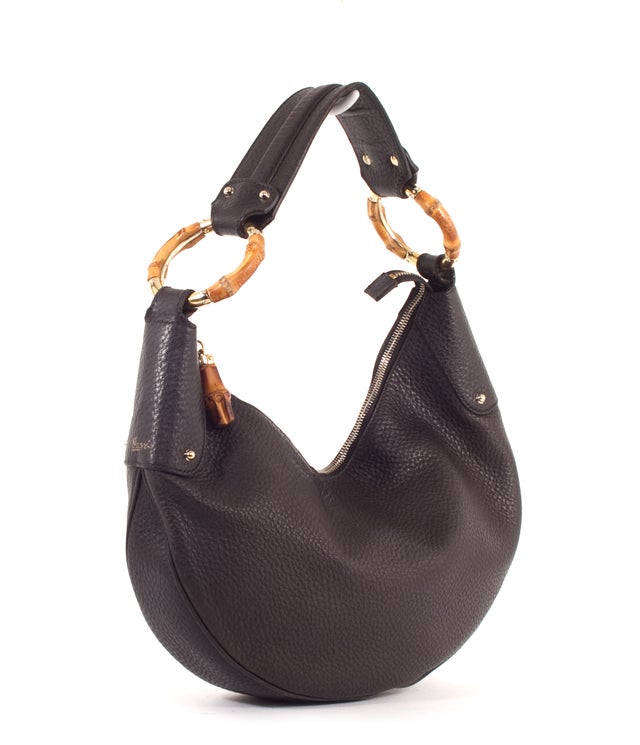This is an authentic GUCCI Black Leather Nappa Crescent Half Moon Hobo Bag. Done in lovely black pebbled leather with black leather trim, this bag features a flat handle, bamboo rings, stud hardware accents and gold toned hardware. There is a single
